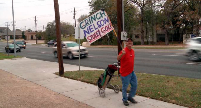 Man Protests Closing of Course with Grinch Sign