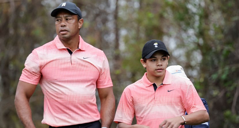 Tiger Woods, left, and his son Charlie Woods, right, prepare to tee off on the 13th hole during the first round of the PNC Championship golf tournament Saturday, Dec. 17, 2022, in Orlando, Fla. (AP Photo/Kevin Kolczynski)