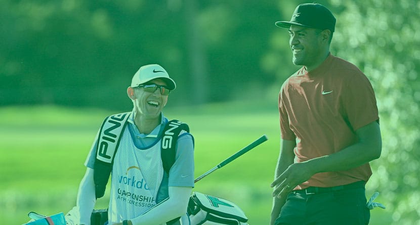 Tony Finau, right, shares a laugh with his caddie while walking on the 18th fairway during the final round of the Workday Championship golf tournament Sunday, Feb. 28, 2021, in Bradenton, Fla. (AP Photo/Phelan M. Ebenhack)