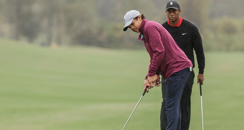 Tiger Woods, background, watches son Charlie, foreground, putt during the final round of the PNC Championship golf tournament, Sunday, Dec. 17, 2023, in Orlando, Fla. (AP Photo/Kevin Kolczynski)
