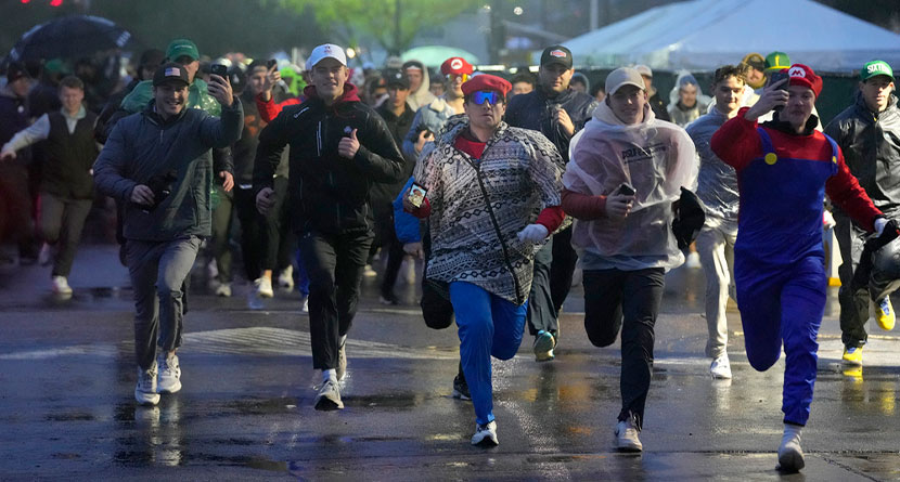 Fans run onto the course prior to the continuation of second round of the Phoenix Open golf tournament Saturday, Feb. 10, 2024, in Scottsdale, Ariz. (AP Photo/Ross D. Franklin)