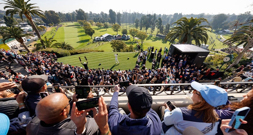 Fans watch as Tiger Woods hits from the first tee during the first round of the Genesis Invitational golf tournament at Riviera Country Club, Thursday, Feb. 15, 2024, in the Pacific Palisades area of Los Angeles. (AP Photo/Ryan Kang)