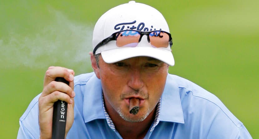 Former NBA basketball player Toni Kukoc, of Croatia, smokes a cigar as he reads his putt on the seventh green during the first round of the Encompass Championship golf tournament on Friday, June 21, 2013, in Glenview, Ill. (AP Photo/Nam Y. Huh)