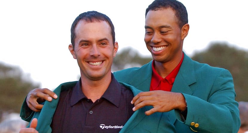 2002 champion Tiger Woods, right, helps Mike Weir don the traditional green jacket after the Canadian won the 2003 Masters, at the Augusta National Golf Club in Augusta, Ga., April 13, 2003. (AP Photo/Elise Amendola)