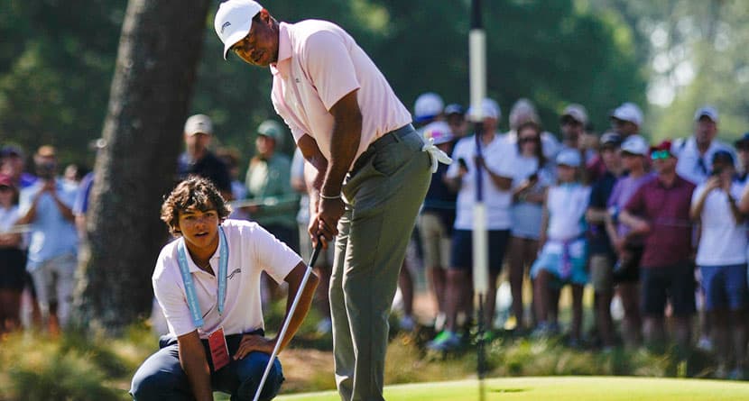 Tiger Woods putts as his son Charlie, watches on the seventh hole during a practice round for the U.S. Open golf tournament Tuesday, June 11, 2024, in Pinehurst, N.C. (AP Photo/George Walker IV)