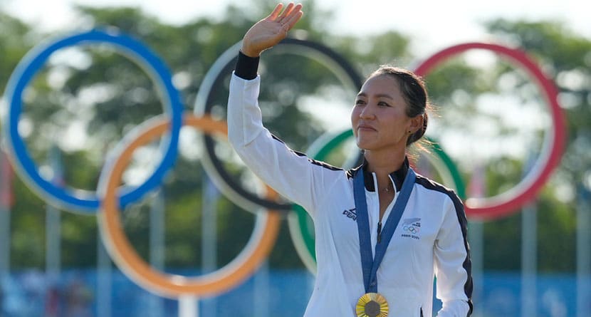 Lydia Ko, of New Zealand, waves to the crowd wearing her gold medal during the medal ceremony following the final round of the women's golf event at the 2024 Summer Olympics, Saturday, Aug. 10, 2024, at Le Golf National, in Saint-Quentin-en-Yvelines, France. (AP Photo/Matt York)