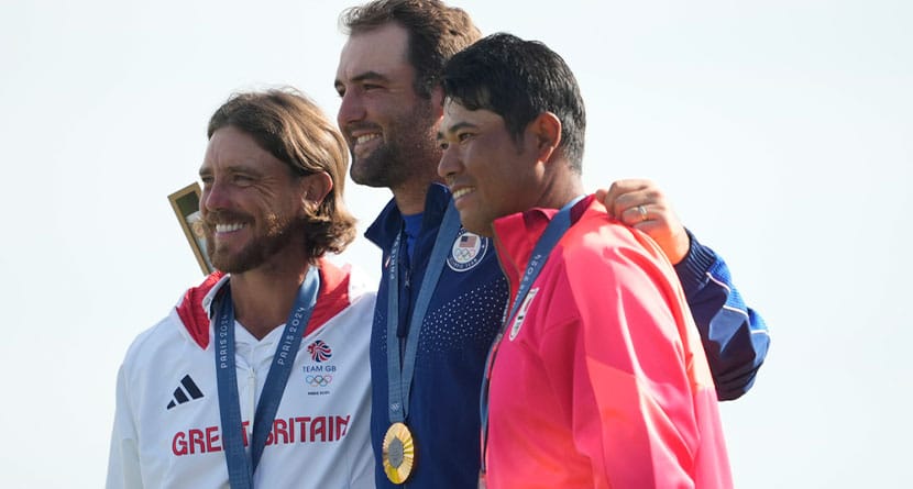 Gold medalist Scottie Scheffler, of the United States, centre, with Tommy Fleetwood, of Britain, silver medal, and Hideki Matsuyama, of Japan, with the bronze medal pose for the media following the medal ceremony for men's golf at the 2024 Summer Olympics, Sunday, Aug. 4, 2024, at Le Golf National in Saint-Quentin-en-Yvelines, France. (AP Photo/Matt York)