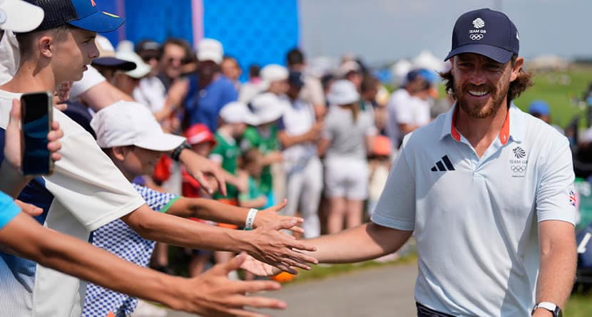 Tommy Fleetwood, of Great Britain, taps hands with fans as he walks to the 15th tee during the second round of the men's golf event at the 2024 Summer Olympics, Friday, Aug. 2, 2024, at Le Golf National in Saint-Quentin-en-Yvelines, France. (AP Photo/George Walker IV)