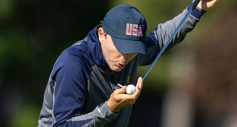 United States team member Russell Henley blows on his ball as he prepares to putt on the fourth hole during practice at the Presidents Cup golf tournament at the Royal Montreal Golf Club in Montreal, Tuesday, Sept. 24, 2024. (Christinne Muschi/The Canadian Press via AP)