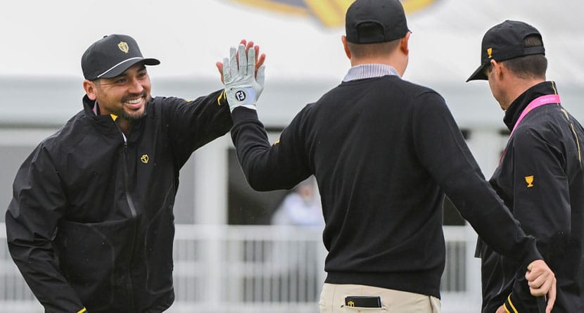 International team member Jason Day, of Australia, left, high-fives teammate Sungjae Im, of South Korea, on the putting green during practice at the Presidents Cup golf tournament, Monday, Sept. 23, 2024, in Montreal. (Christinne Muschi/The Canadian Press via AP)