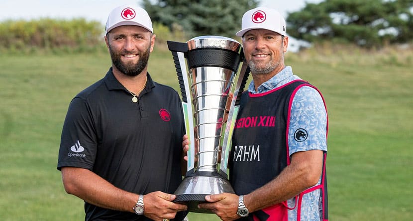 2024 Individual Champion captain Jon Rahm, left, of Legion XIII, and his caddie, Adam Hayes, right, pose with the Individual Championship Trophy after the final round of LIV Golf Chicago at Bolingbrook Golf Club, Sunday, Sept. 15, 2024, in Bolingbrook, Ill. (Montana Pritchard/LIV Golf via AP)