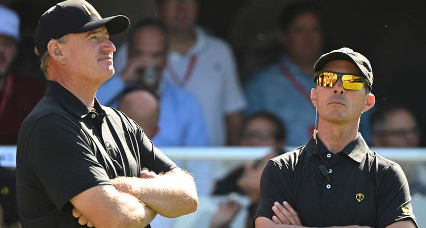 International team captain Mike Weir, right, chats with assistant captain Ernie Els on the first tee during their fifth round singles match at the Presidents Cup golf tournament at Royal Montreal Golf Club on Sunday, Sept. 29, 2024 in Montreal. (Graham Hughes/The Canadian Press via AP)