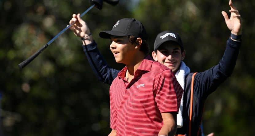 Charlie Woods, front, and his caddie Luke Wise react after his hole-in-one on the fourth hole during the final round of the PNC Championship golf tournament, Sunday, Dec. 22, 2024, in Orlando, Fla. (AP Photo/Phelan M. Ebenhack)