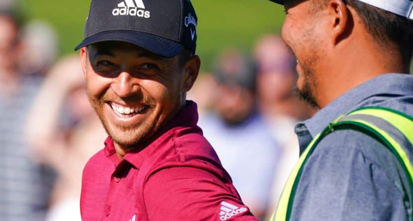 Xander Schauffele laughs with his caddie on the ninth hole during the second round of the Phoenix Open golf tournament Friday, Feb. 11, 2022, in Scottsdale, Ariz. (AP Photo/Darryl Webb)