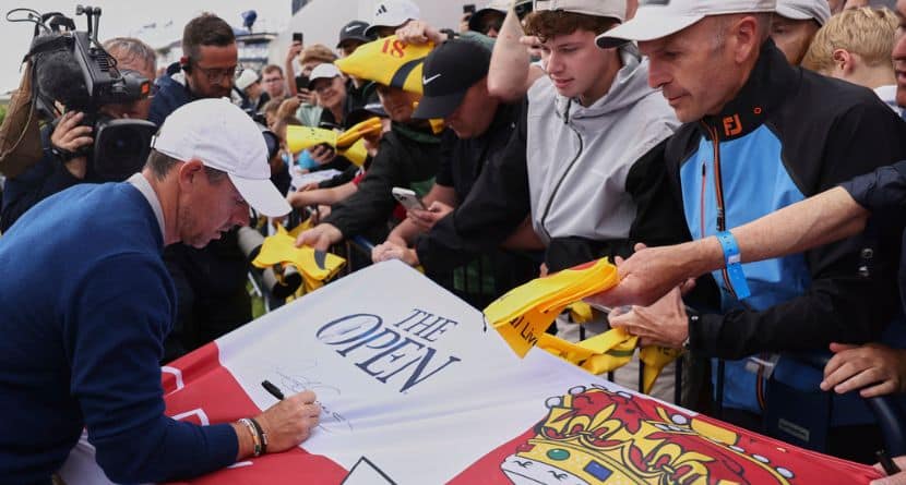 Rory McIlroy of Northern Ireland signs a replica Northern Ireland flag on the 18th green following a practice round for the 2025 British Open golf championship at the Royal Portrush Golf Club, Northern Ireland, Monday, July 14, 2025. (AP Photo/Peter Morrison)