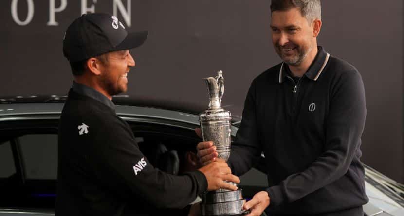 Xander Schauffele of the United States, left, winner of the 2024 British Open, hands back the Claret Jug trophy to the R&A CEO Mark Darbon ahead of the 2025 British Open golf championship at the Royal Portrush Golf Club, Northern Ireland, Monday, July 14, 2025. (AP Photo/Fransisco Seco)