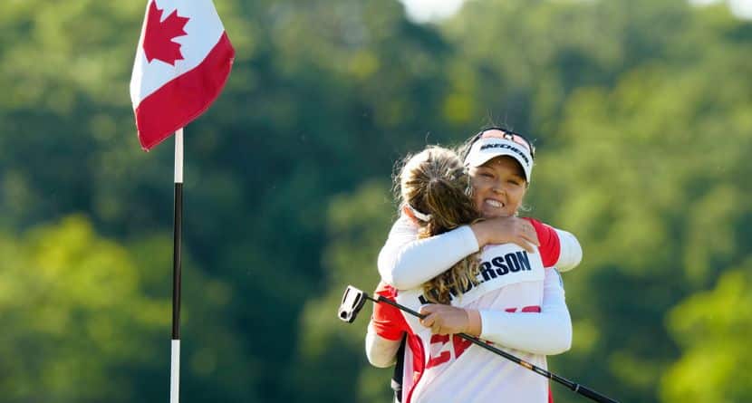 Brooke Henderson, right, of Canada, hugs her caddie, and sister, Brittany Henderson, left, after winning the Canadian Women's Open golf tourrnament on the 18th hole in Mississauga, Ontario, Sunday Aug. 24, 2025. (Frank Gunn/The Canadian Press via AP)