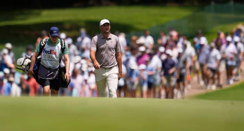 Scottie Scheffler and his caddie walk on the first fairway during the final round of the St. Jude Championship golf tournament Sunday, Aug. 10, 2025, in Memphis, Tenn. (AP Photo/George Walker IV)