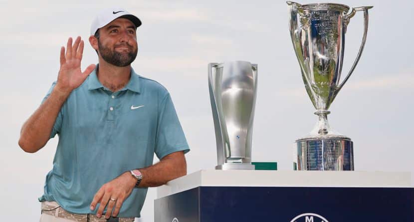 Scottie Scheffler waves while standing with trophies after winning the BMW Championship golf tournament Sunday, Aug. 17, 2025, in Owings Mills, Md. (AP Photo/Stephanie Scarbrough)