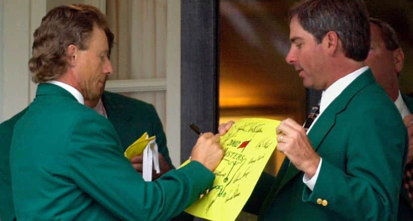 Former two-time Masters Champion Bernhard Langer, left, signs an autograph for fellow former champion Fred Couples, right, at the Augusta National Golf Club prior to the annual Champions dinner at the 2002 Masters, April 9, 2002, in Augusta, Ga. (AP Photo/Dave Martin)