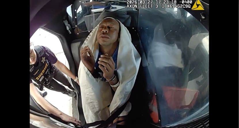 In this image from video provided by the Martin County, Fla., Sheriff's Office, golfer Tiger Woods is strapped into a police vehicle following a car crash in Jupiter Island, Fla., Friday, March 27, 2026. (Martin County Sheriff's Office via AP)