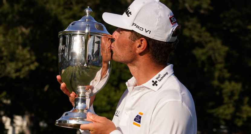Michael Brennan kisses the trophy after winning the Wyndham Championship golf tournament in Greensboro, N.C., Sunday, Aug. 9, 2026. (AP Photo/Chuck Burton)